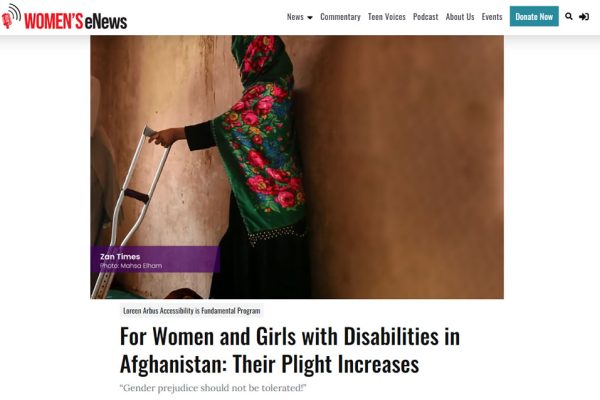 Image of a woman from Afghanistan leaning against a wall, holding a crutch.