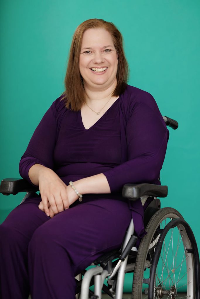 Dawn Grabowski in a wheelchair wearing a purple shirt and pants