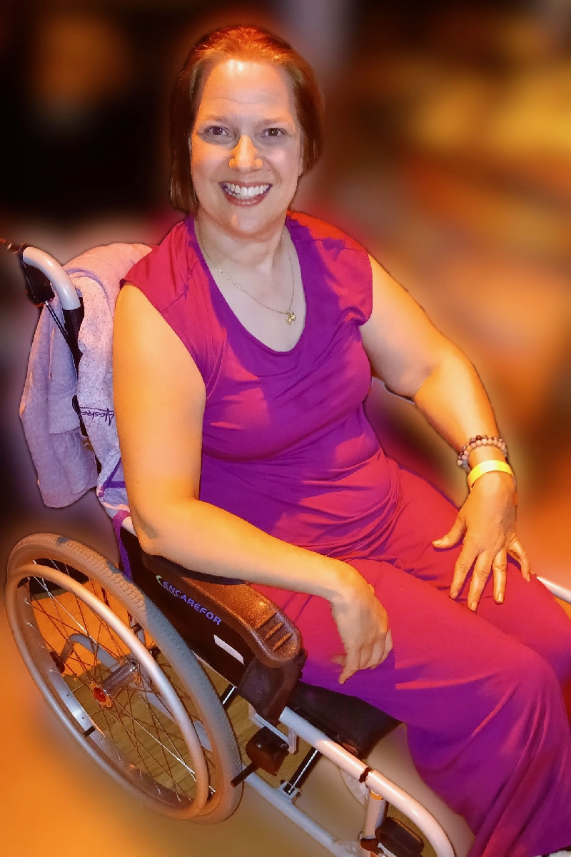Dawn Grabowski in a purple dress in her wheel chair