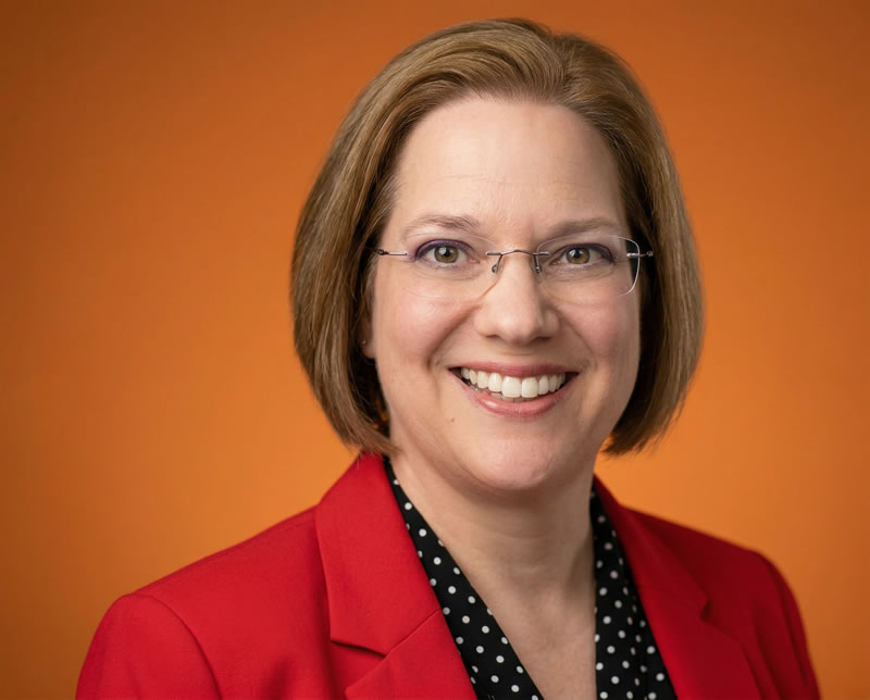 Dawn wearing glasses and a red blazer