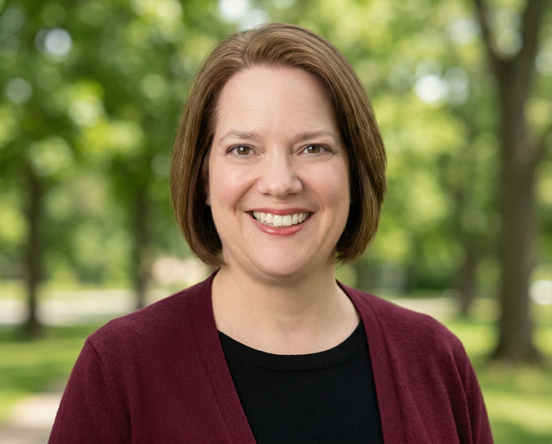 Dawn wearing a maroon sweater and black knit top